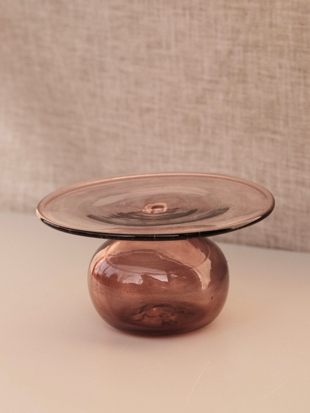 Candle holder or vase made from a raspberry coloured glass. The top is a round disk perfect for a large single flower to sit on. Handblown in Paris.