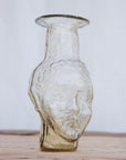 Small clear glass vase in the shape of a head. Use it as a vase, candleholder or creamer. Handblown in Paris by La Soufflerie.