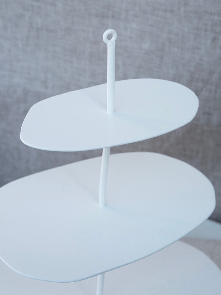 close up of the first two levels of the white etagere from above. It showcases the beauty in the wonky nature of the flat display area and metal stand.