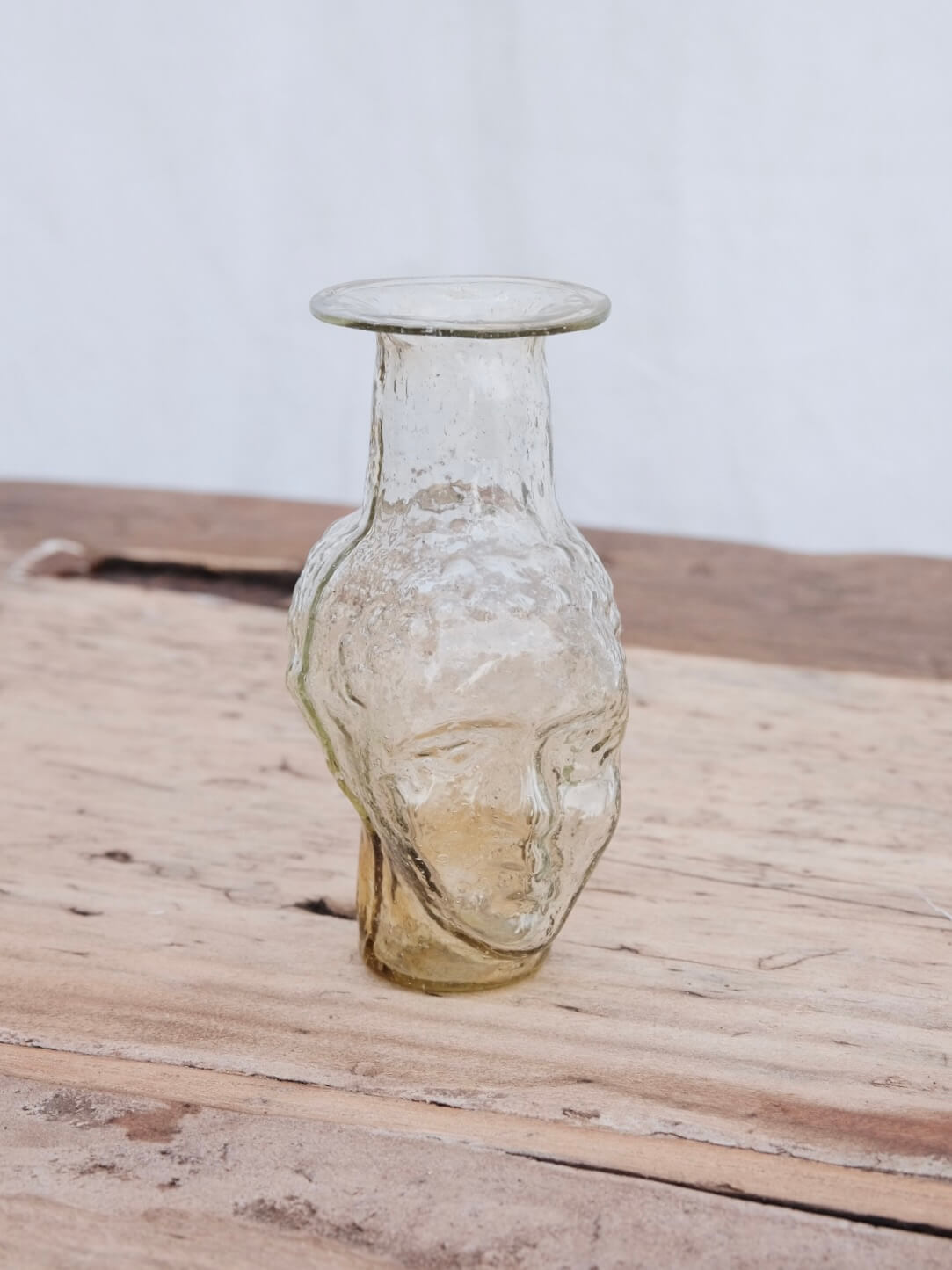 Small clear glass vase in the shape of a head. Use it as a vase, candleholder or creamer. Handblown in Paris by La Soufflerie.