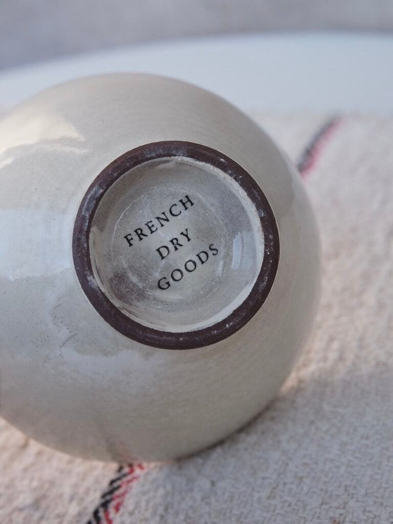 close up of the base of a cream coloured small bowl with the brand name French Dry Goods printed on the base.
